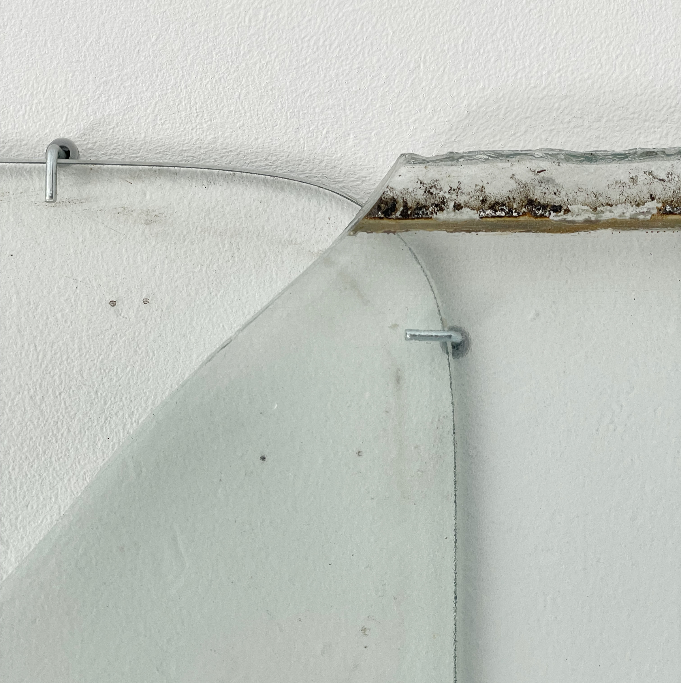 Anneke Eussen, Planning the past 01, 2025, car pane, recycled glass, coloured glass, metal hooks, mounted to the wall, 147 x 75 cm, unique
