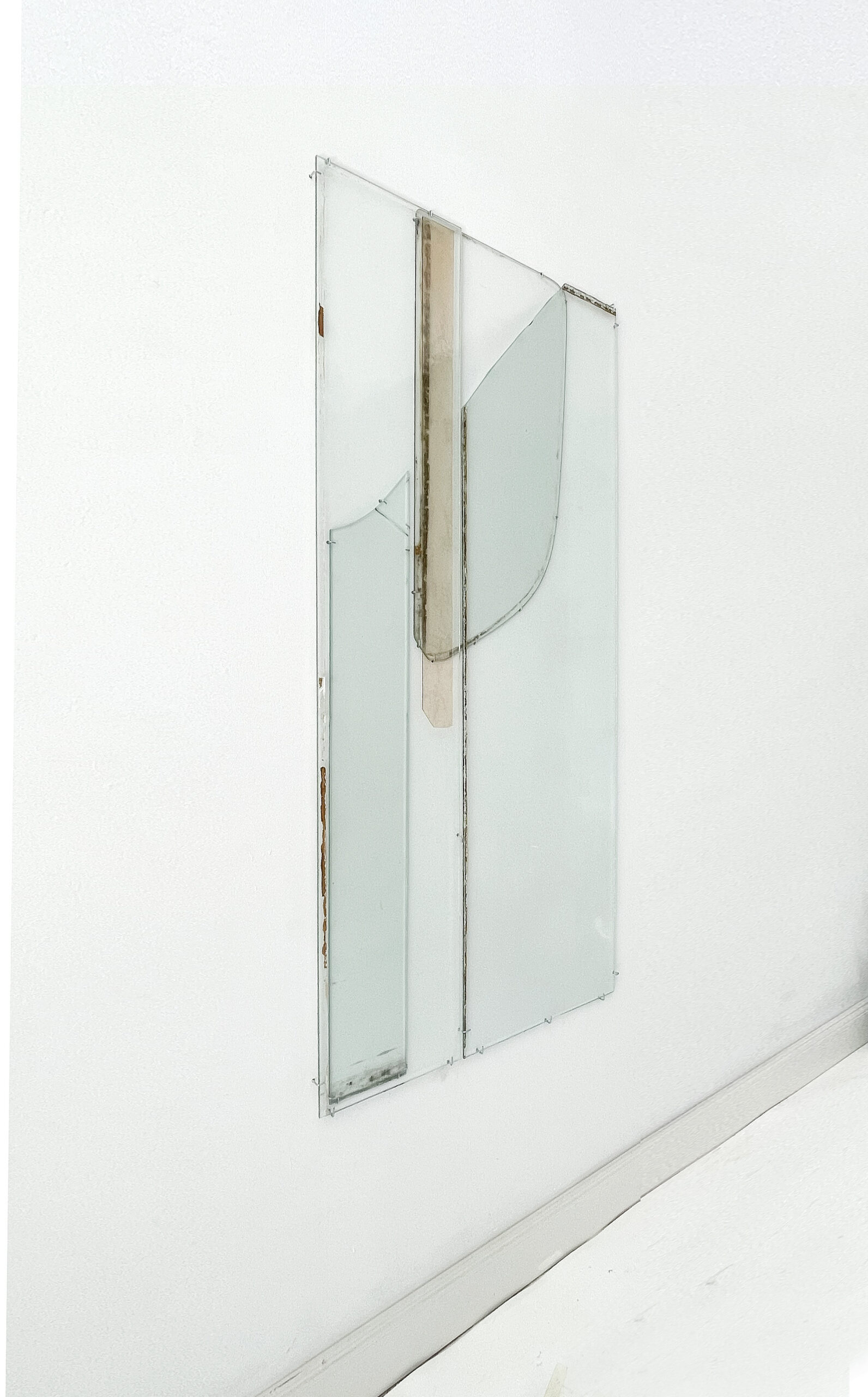 Anneke Eussen, Planning the past 01, 2025, car pane, recycled glass, coloured glass, metal hooks, mounted to the wall, 147 x 75 cm, unique