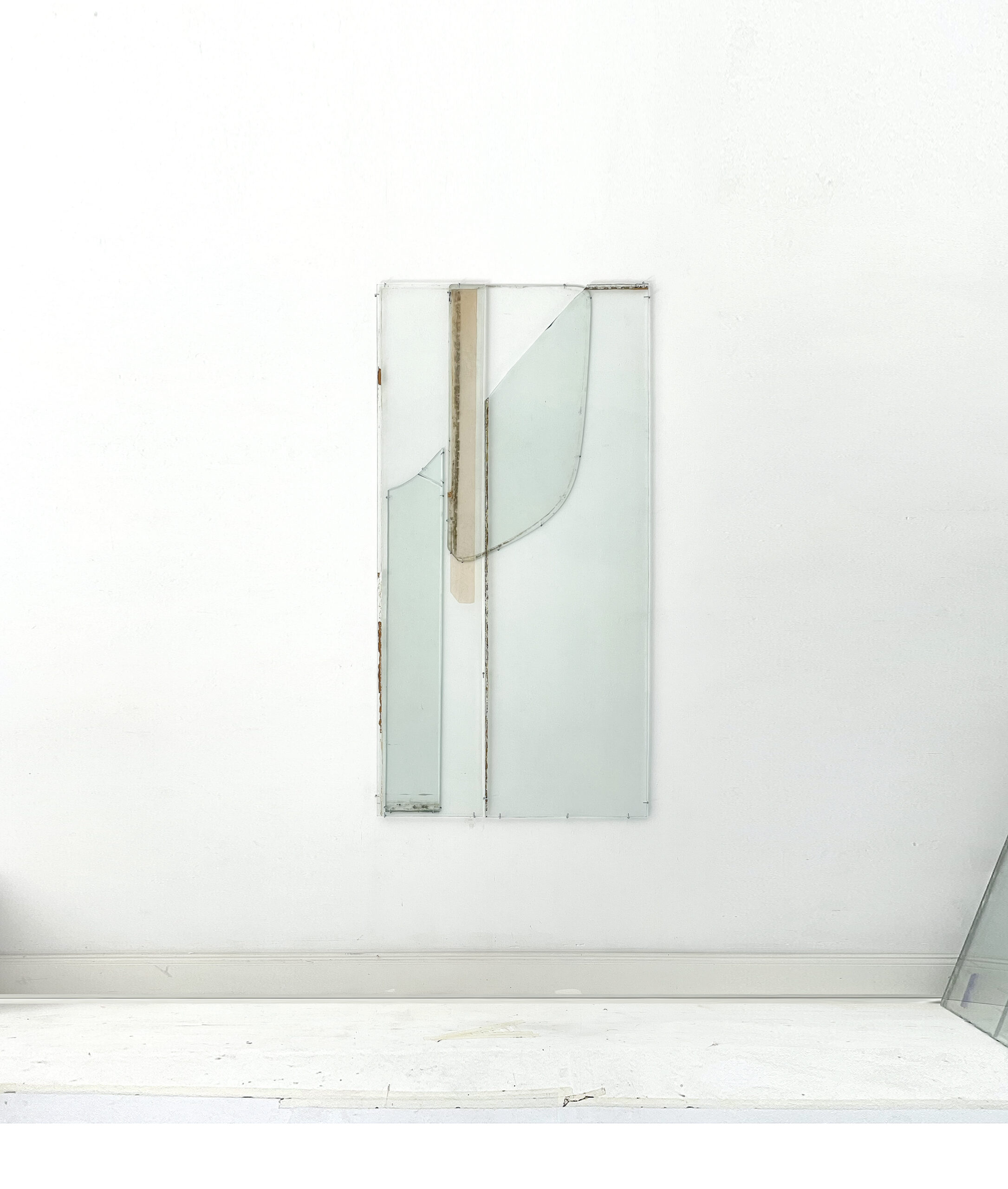 Anneke Eussen, Planning the past 01, 2025, car pane, recycled glass, coloured glass, metal hooks, mounted to the wall, 147 x 75 cm, unique